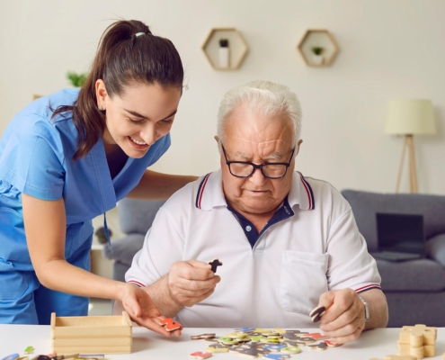 Caretaker Helping Dementia Patient With Puzzle