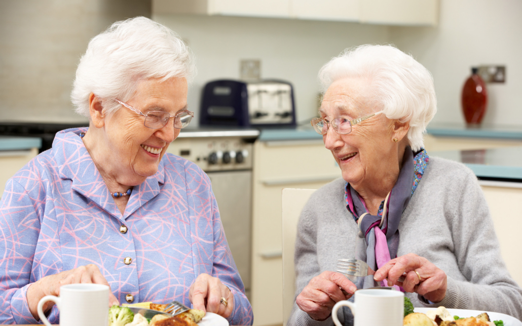 Senior Women Enjoying Meal Together At Home
